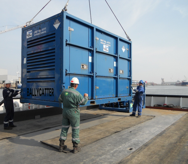 Workers guiding a large industrial equipment showcasing Ballycatter’s role in equipment logistics and handling.